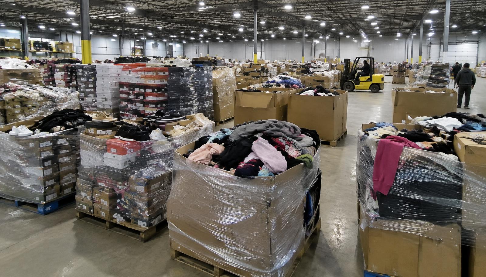 Warehouse with wrapped pallets of clothing and shoe boxes